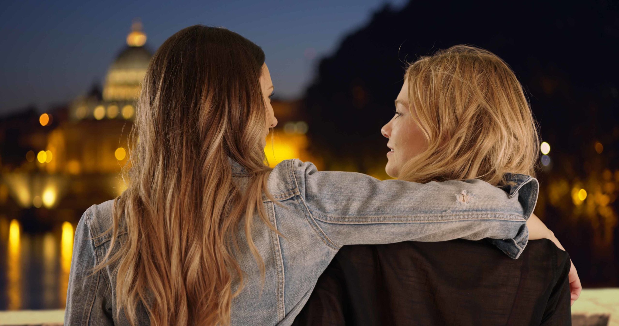 Young brunette with arm around blonde friend's shoulder in Rome Italy